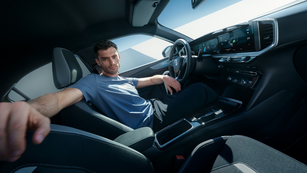 Mann auf dem Fahrersitz eines Opel Mokka Electric schaut auf den Beifahrersitz